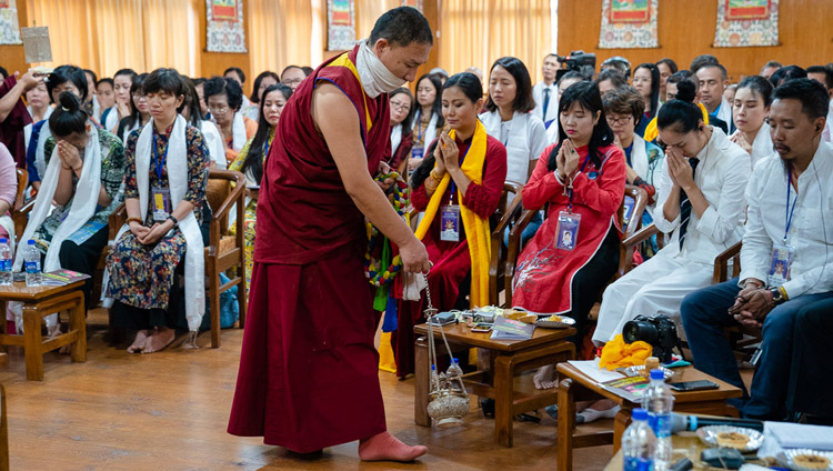 An assistant performing ritual cleansing with incense as His Holiness the Dalai lama gives the White Manjushri Permission on the second day of his meeting with groups from Vietnam at his residence in Dharamsala, HP, India on May 22, 2018. Photo by Tenzin Choejor